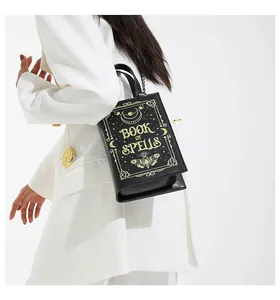 Unique book-shaped crossbody bag with gold 'Book of Spells' print on black leather.