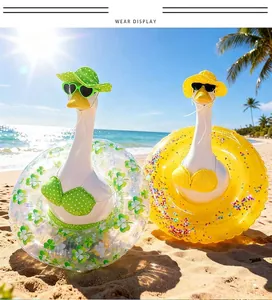 Close-up of decorative geese wearing vibrant summer bikinis and floaties on the sand