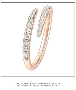 Primo piano di un anello aperto in oro rosa minimalista con cristalli scintillanti