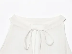Close-up detail of a white linen halter neck top with tie-up closure and soft fabric texture