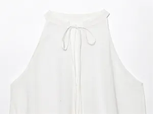 Close-up detail of a white linen halter neck top featuring a delicate tie-up collar