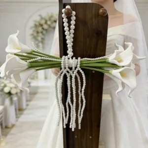 Squisito accessorio fatto a mano in perle bianche usato come cinturino per fiori nuziali