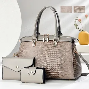 Detail of 3-piece handbag set featuring crocodile embossed texture and patent finish