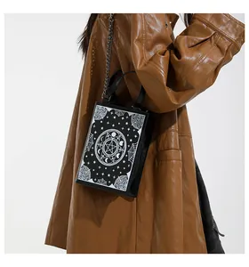 Detail view of gothic mystical pattern on a black box-shaped crossbody bag