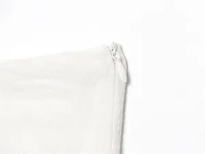 Detailed close-up showing the invisible white zipper on a textured linen fabric garment