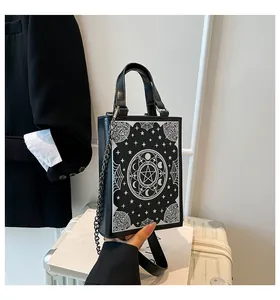 Detailed view of a gothic book-shaped handbag with occult pentagram and star patterns