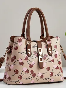Stylish beige women's handbag featuring a playful pink cherry print and brown top handles