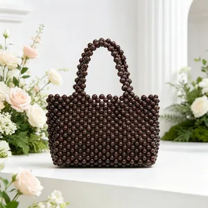 Borsa a mano in perline marroni fatta a mano per vacanze al mare con sfondo floreale