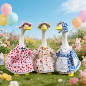 Three garden goose statues wearing colorful strawberry and floral themed outfits and hats.