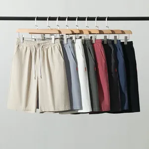 Divers coloris de shorts décontractés en coton et lin pour hommes sur des cintres.