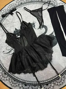 Detailansicht eines schwarzen Spitzen-Lingerie-Sets mit Bodysuit, T-String und Strümpfen.
