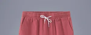 Détail de la taille élastique et du cordon de serrage blanc sur un short rouge pour homme