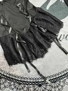 Nahaufnahme von schwarzem Spitzen-Body mit eleganten Bändern und Strumpfhalter-Details
