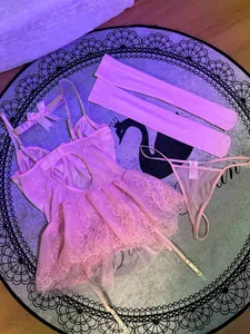 Detailansicht eines rosa Spitzen-Bodysuit-Lingerie-Sets mit Strümpfen und Tanga