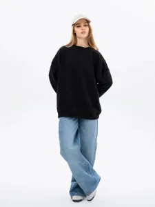 Full body view of women's black oversized round neck sweatshirt in minimalist style