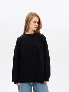 Detailed view of women's oversized black crewneck sweatshirt in a minimalist style