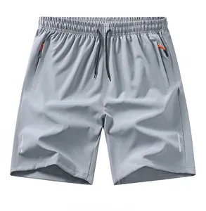 Dettaglio di pantaloncini sportivi grigi con tasche con zip e strisce riflettenti di sicurezza.