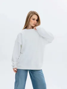 Detailed view of a thick white oversized crewneck sweatshirt worn by a female model
