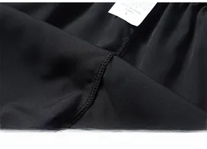 Dettaglio delle cuciture rinforzate e della trama in seta ghiaccio dei pantaloncini neri