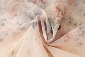 Gros plan sur un tissu en tulle léger avec un motif floral aux tons pastels doux