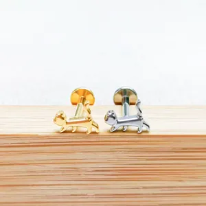 Detailed view of cat-shaped titanium labret studs in gold and silver finishes
