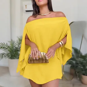 Detail of yellow off-the-shoulder dress featuring unique split cape-style sleeves