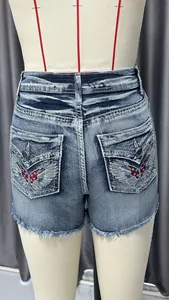 Detailed back view of vintage-style denim shorts featuring wing embroidery and frayed hems