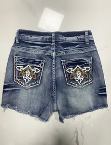 Detailed back view of women's vintage denim shorts featuring intricate pocket embroidery