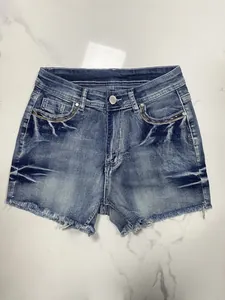 High-waisted American retro blue denim shorts with embroidery and raw edge hems.