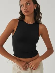 Detail view of a black sleeveless round neck cropped yoga tank top on a female model