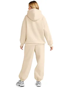Woman wearing a beige oversized hooded sweatshirt and matching jogger set from behind.