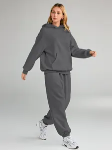 Full detail shot of a grey oversized hoodie and sweatpants set worn by a female model.