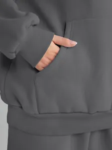 Close-up of grey oversized hoodie pocket and ribbed cuffs in a casual sports set