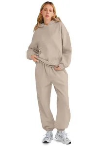 Full-body studio shot of a model wearing a light beige oversized hoodie and sweatpants