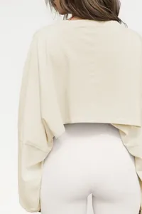 Detailed back view of a cream cropped crewneck sweatshirt paired with white leggings