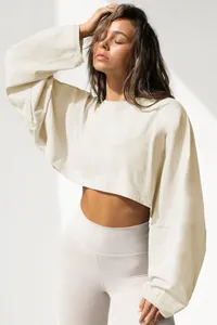 Detailed view of the beige cropped sweatshirt with ribbed cuffs and round neck.
