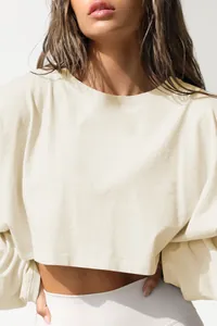 Close-up of cream cropped crewneck long sleeve sweatshirt showing fabric texture.