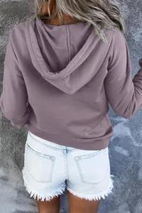 Rückansicht eines modischen lila Kapuzenpullovers kombiniert mit weißen Jeansshorts