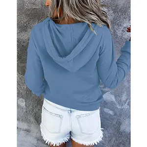 Rückansicht eines blauen, locker sitzenden Kapuzenpullovers für Damen im Herbststil