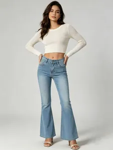 Full-length view of women's high-waisted light blue flare jeans with a white crop top