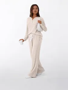 Cozy beige ribbed knit two-piece lounge set with long-sleeved top and wide-leg pants.