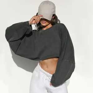Close-up detail of dark grey cropped long sleeve crewneck sweatshirt with raw hem