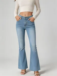Close-up view of stylish high-waisted flare denim jeans in light blue wash on model