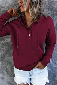 Detailaufnahme eines weinroten Damen-Kapuzenpullovers mit Knöpfen und Tasche