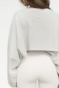 Rear detail view of a minimalist light gray cropped long-sleeve sweatshirt for women.