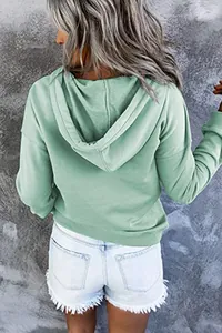 Rückansicht eines stilvollen, lässigen, lockeren salbeigrünen Kapuzenpullovers für Damen