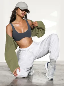 Detail view of women's stylish olive green shrug and white sweatpants sports outfit set