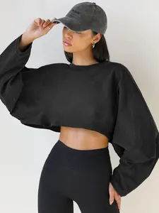 Model wearing a black cropped crewneck sweatshirt with long sleeves and black leggings