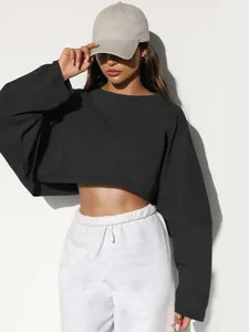 Close-up of a women's black cropped crewneck sweatshirt with long sleeves in streetwear style.