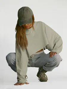 Stylish women's cropped khaki crewneck sweatshirt with long sleeves shown on a model